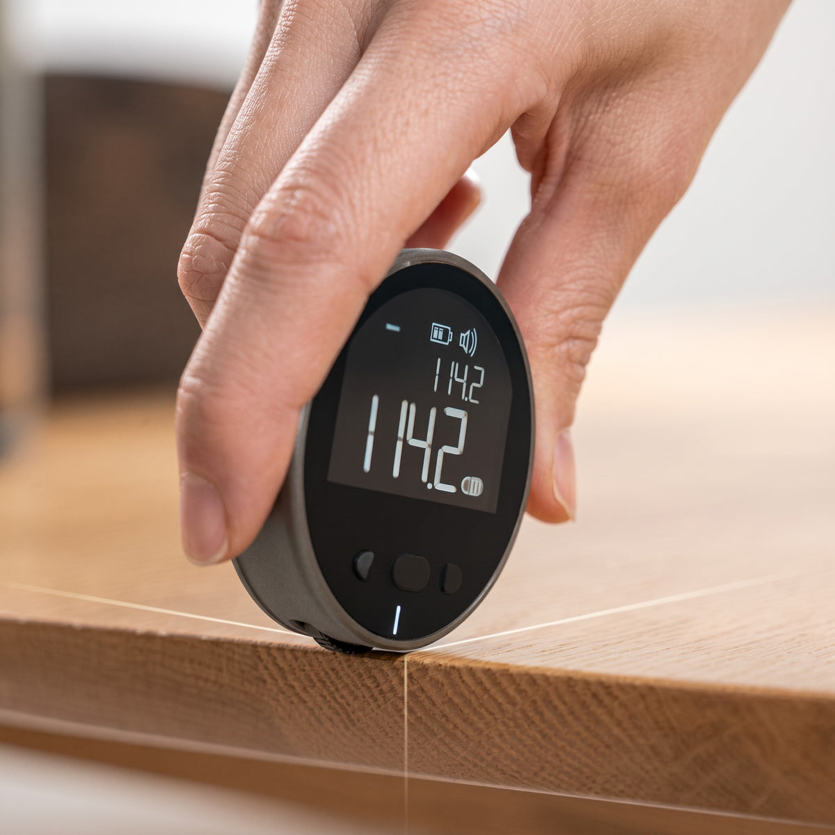 EVEREASE digital electronic rolling distance measurer tool being used to measure a wooden table edge