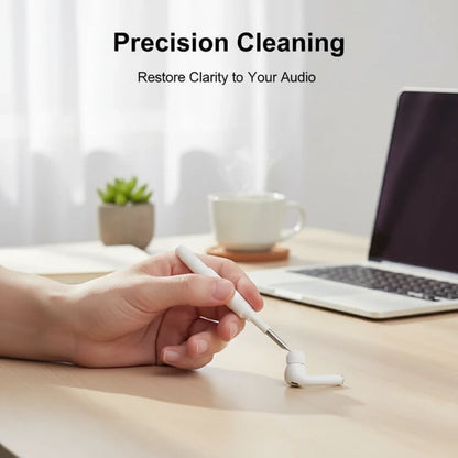 EVEREASE HAGiBiS white earbuds cleaning pen tool being used to clean a wireless earbud on a wooden desk