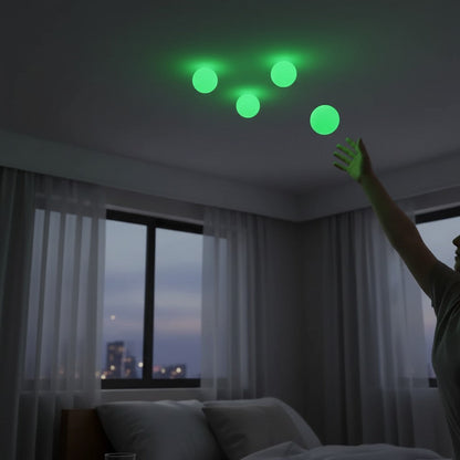 EVEREASE glow-in-the-dark sticky ceiling balls glowing green on a bedroom ceiling with a person reaching up