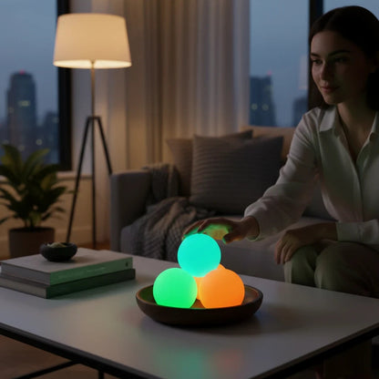 EVEREASE glowing sticky ceiling balls in green and orange on a wooden tray in a cozy dimly lit living room